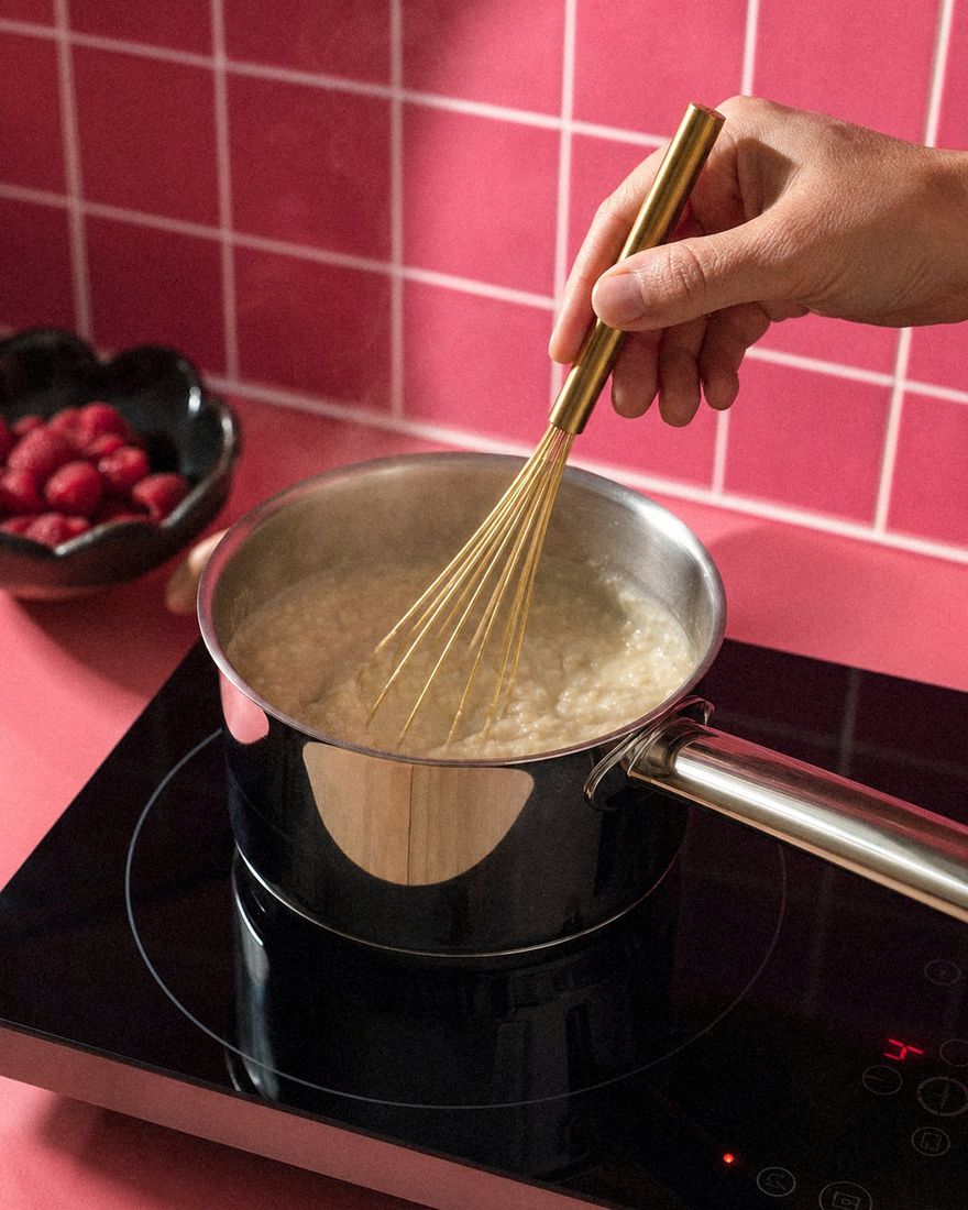 Porridge wird im Edelstahl-Topf sanft erwärmt und mit Brass-Schneebesen gerührt