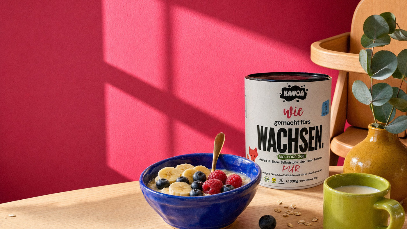 Frühstückstisch im Morgenlicht: Kinderschale mit Porridge, Kavoa Dose und Hochstuhl vor Hot-Pink-Wand